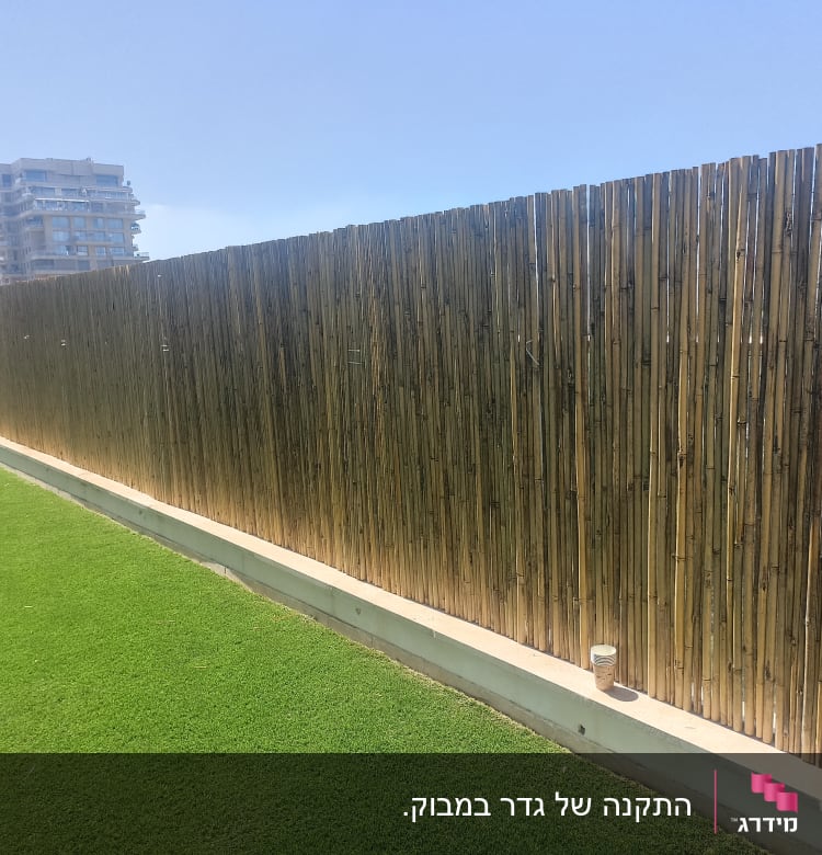 גדר במבוק גבוהה על דשא ירוק